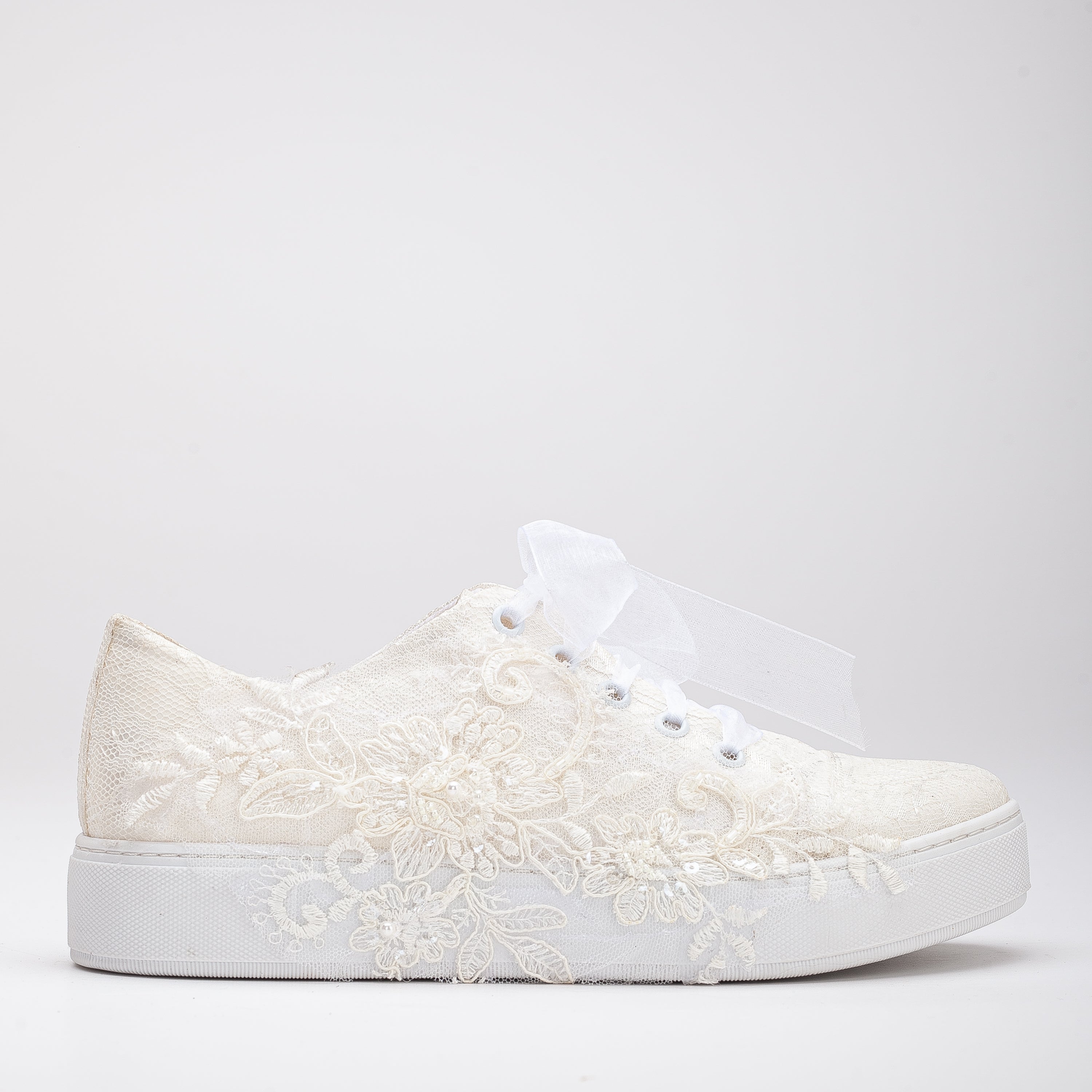 White wedding sneakers, Bridal sneakers in white, Wedding tennis shoes in white, White bridal trainers, White lace-up wedding sneakers, White canvas bridal sneakers, White platform wedding sneakers, White embellished wedding sneakers, White high-top wedding sneakers, White slip-on bridal sneakers.